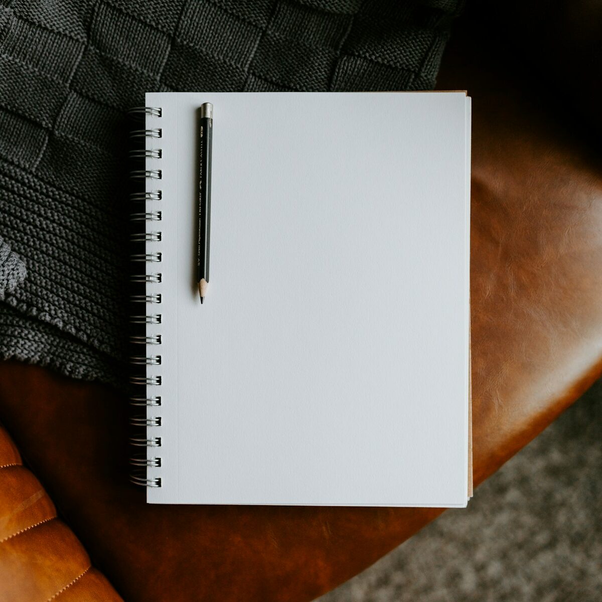 a notepad sitting on top of a brown leather chair